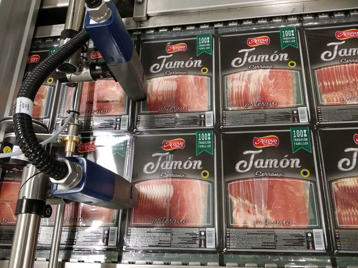 packs of ham being printed by a domino continuous inkjet printer